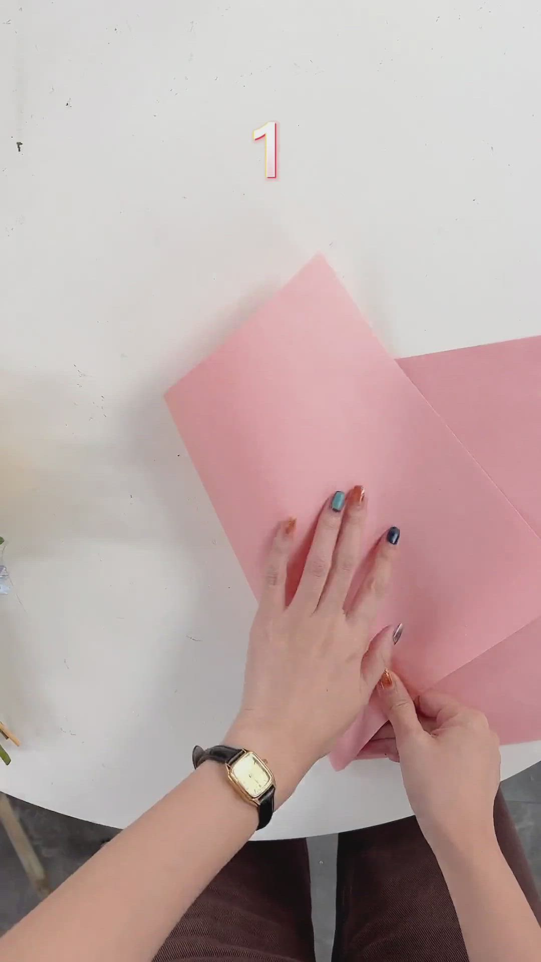 This may contain: a woman is making pink paper cones with the words, 10 ways to wrap a bouquet