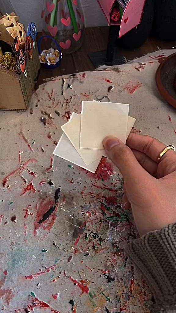 This may contain: two origami stars sitting on top of a table covered in paint and paper