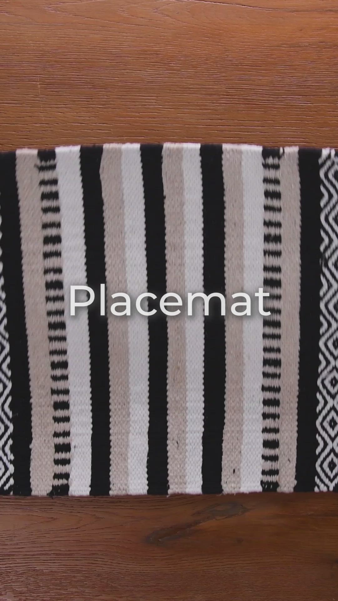 This may contain: a black and white striped rug sitting on top of a wooden floor next to a remote control