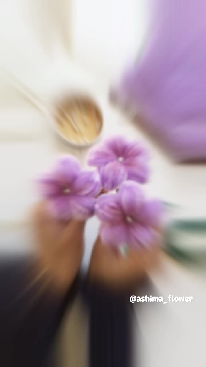 This may contain: blurry photograph of purple flowers in front of a bed