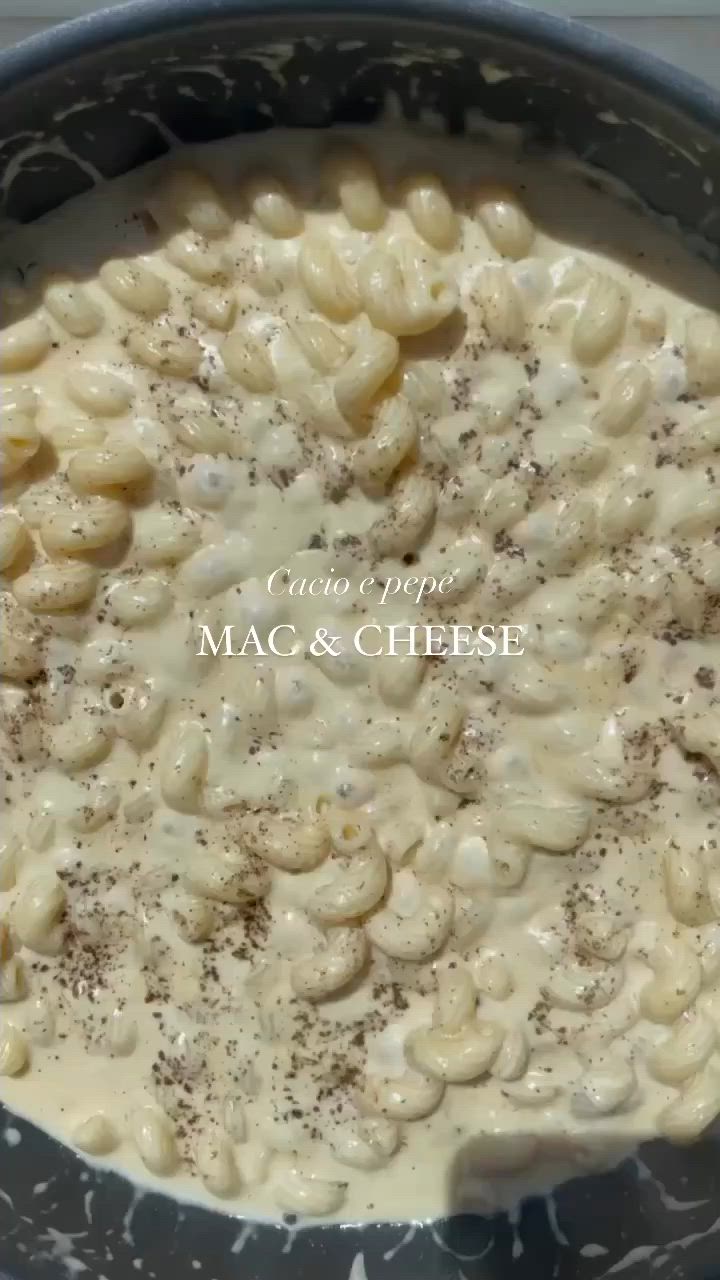 This may contain: macaroni and cheese being cooked in a skillet