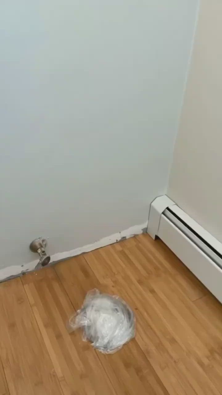 This may contain: a white radiator sitting on top of a hard wood floor next to a wall