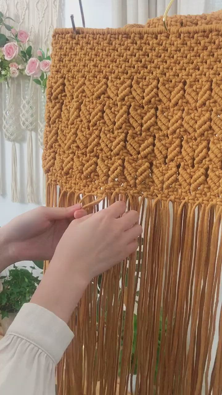 This may contain: a woman is working on a weaving project