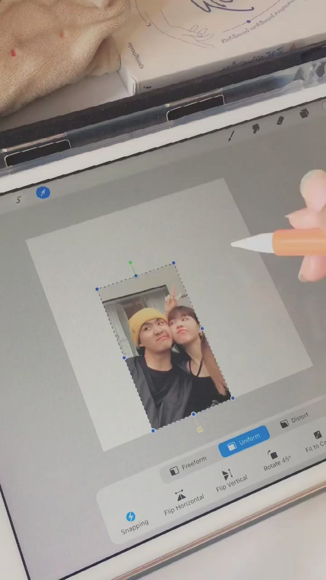 This may contain: a person holding a pencil in front of a laptop screen with a photo on it