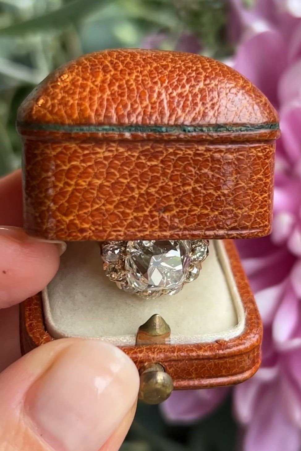 This may contain: someone is holding an old diamond ring in their hand and it's inside the box