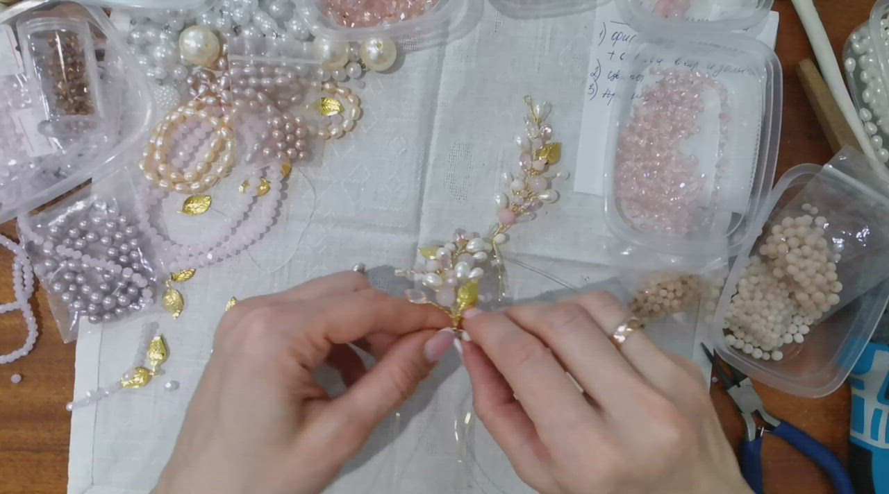 This may contain: a woman is working on some beading in her craft room with beads and pearls