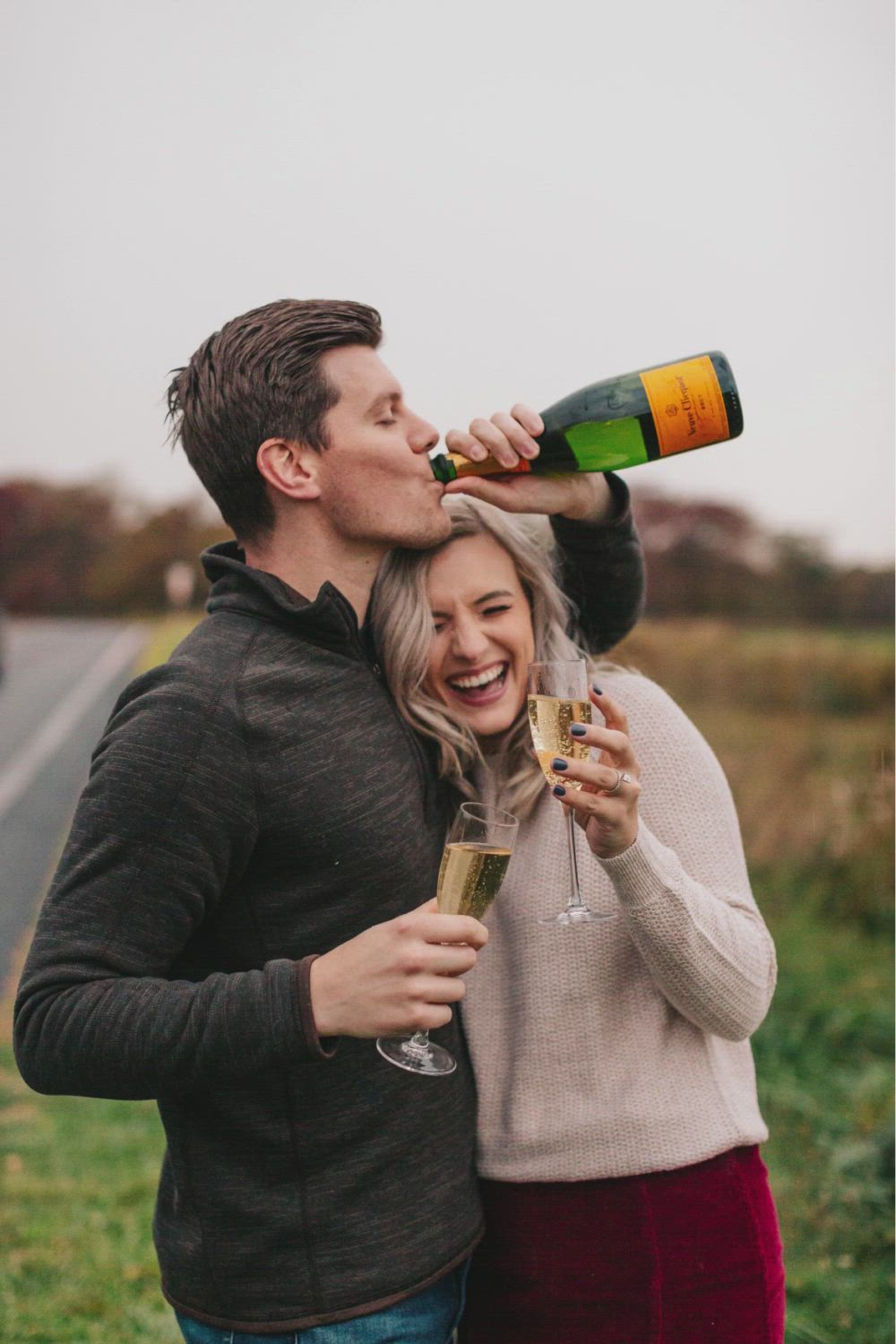 This may contain: a man and woman standing next to each other drinking champagne