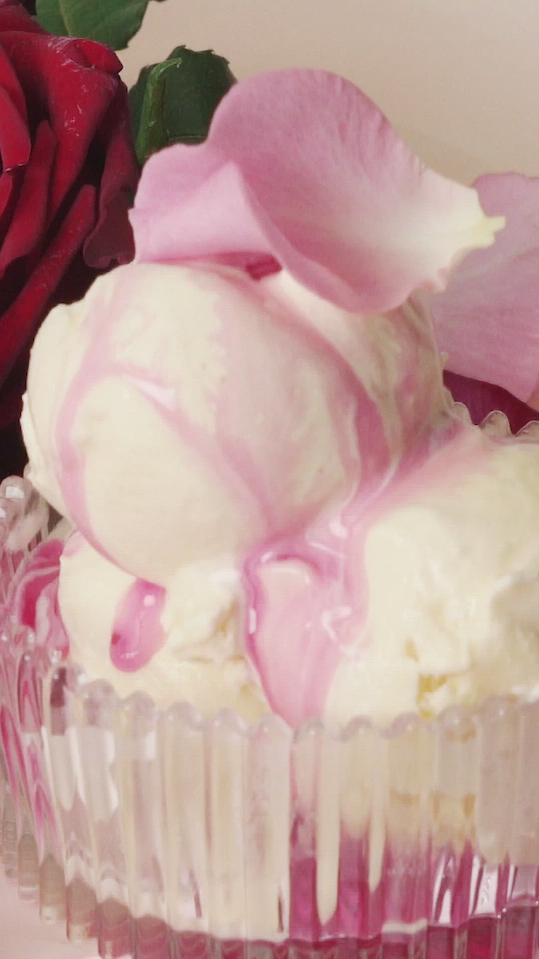 This may contain: a close up of a cupcake with ice cream and flowers in the background text reads rose petal ice cream