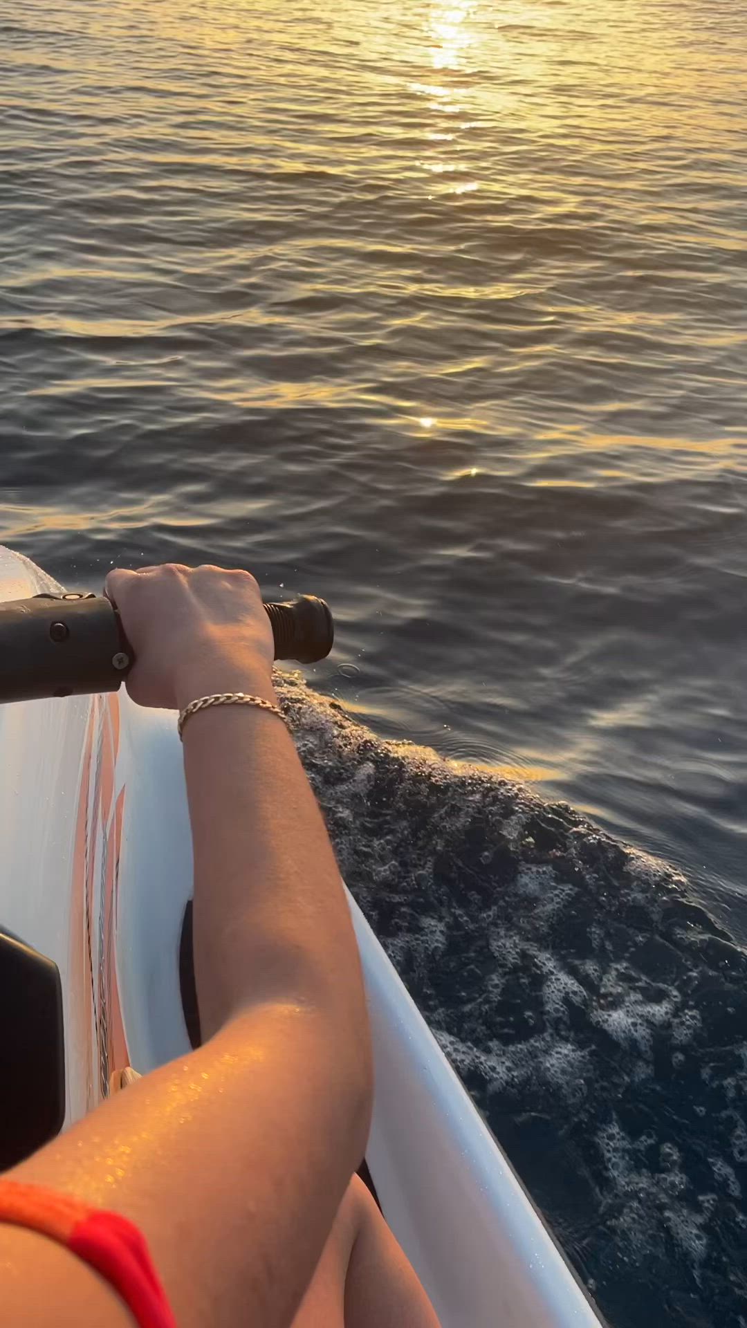 This may contain: the sun is setting over the ocean as a person rides in a boat