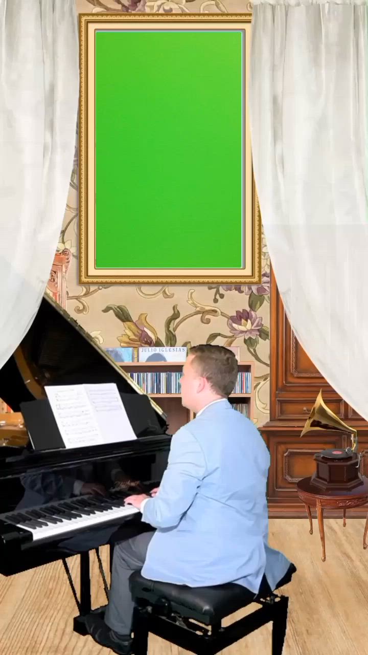 This may contain: a man sitting at a piano in front of a green screen