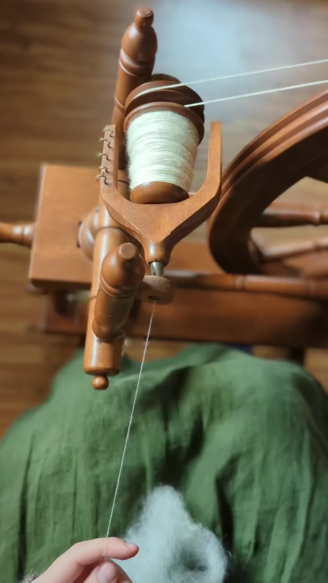 This may contain: someone is weaving something on a wooden loom with white yarn in the foreground