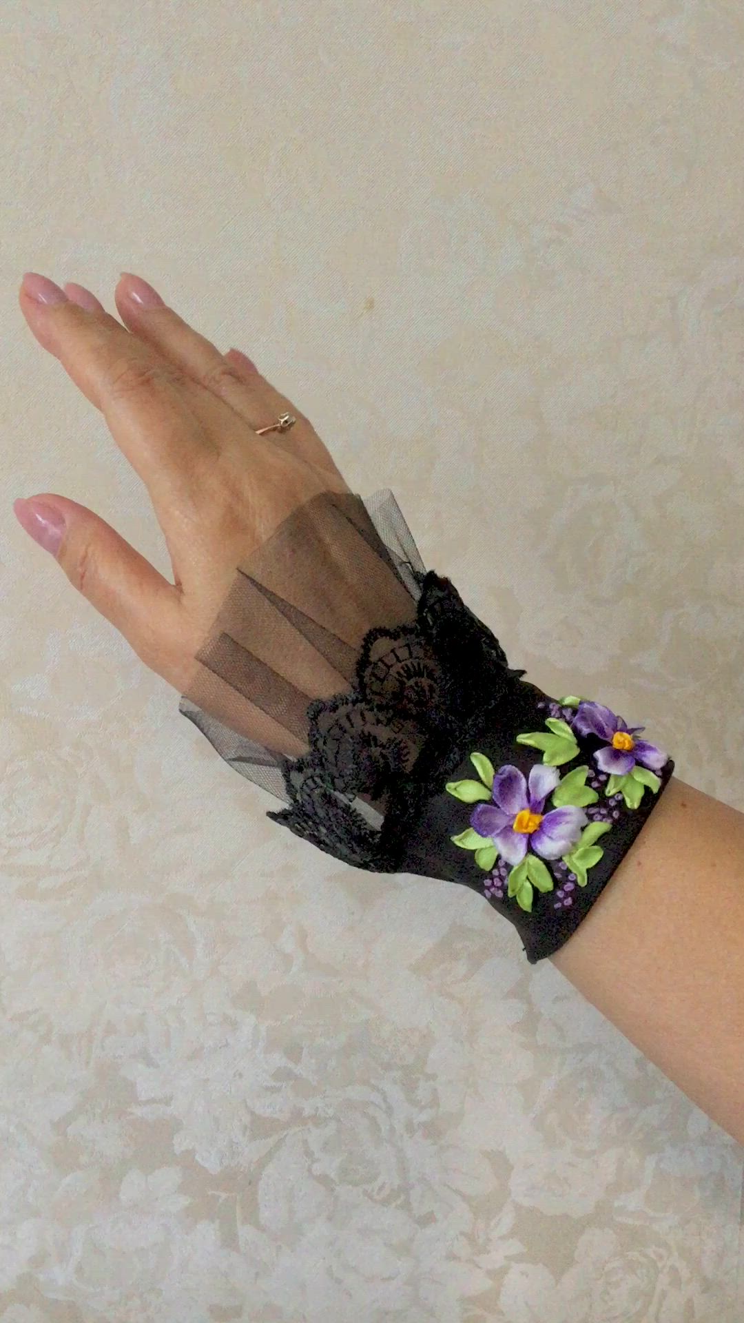 This may contain: a woman's hand with black lace and flowers on it