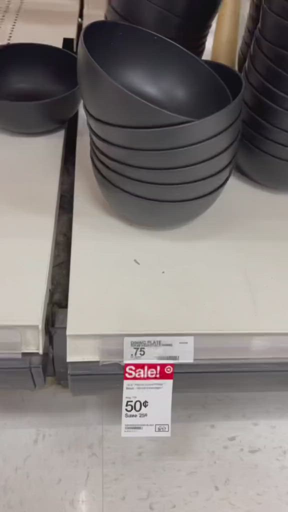 This may contain: black bowls are stacked on top of each other for sale at the store's counter