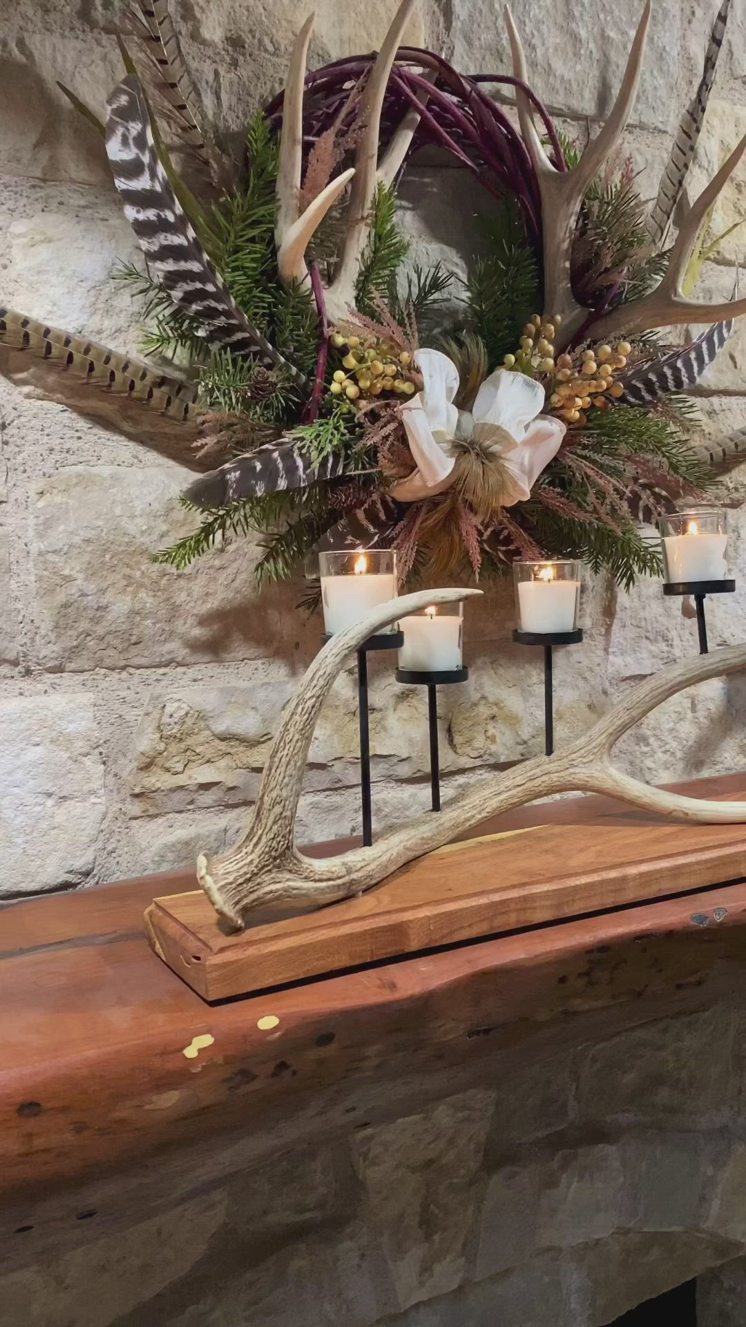 This may contain: a fireplace mantle with antlers and candles on it