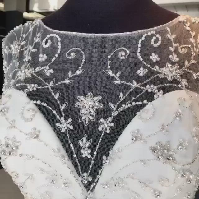 This may contain: the back of a wedding dress with beading and sequins on it's neck