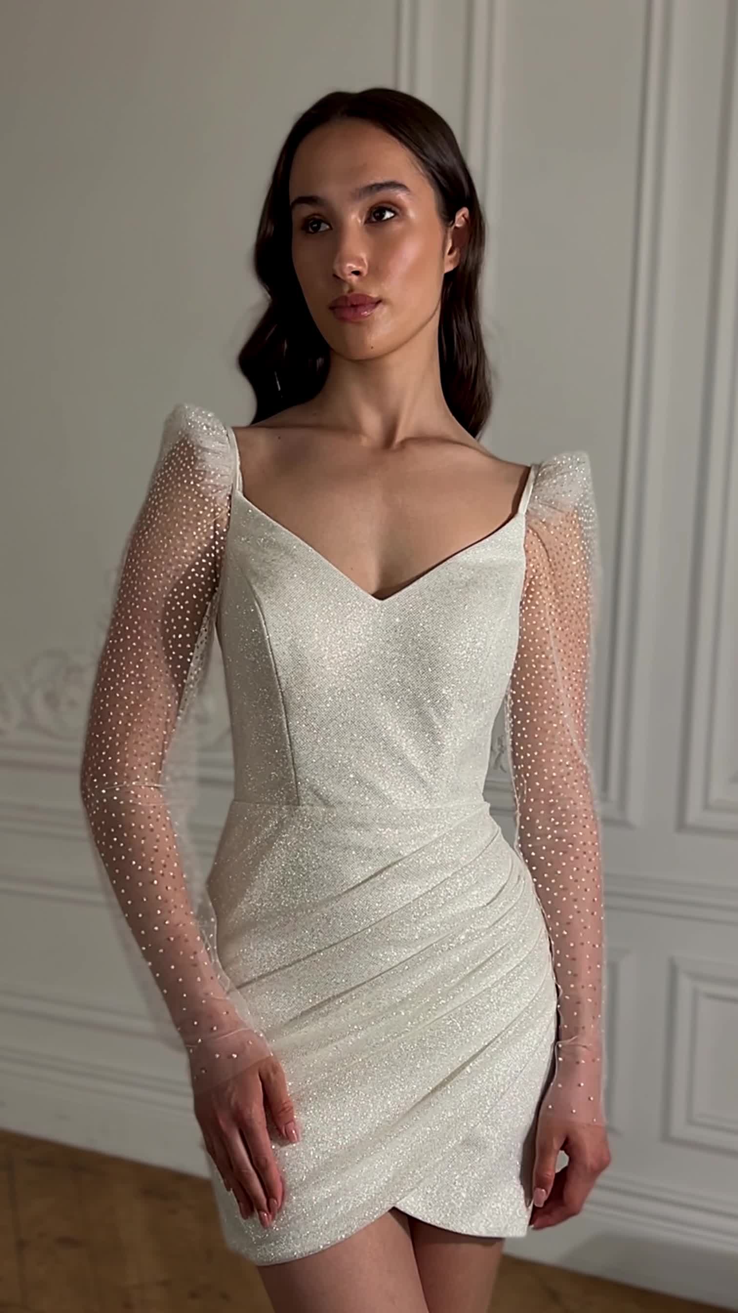 This contains: Classic sheath short sparkly after party wedding dress with detachable long puffed sleeves