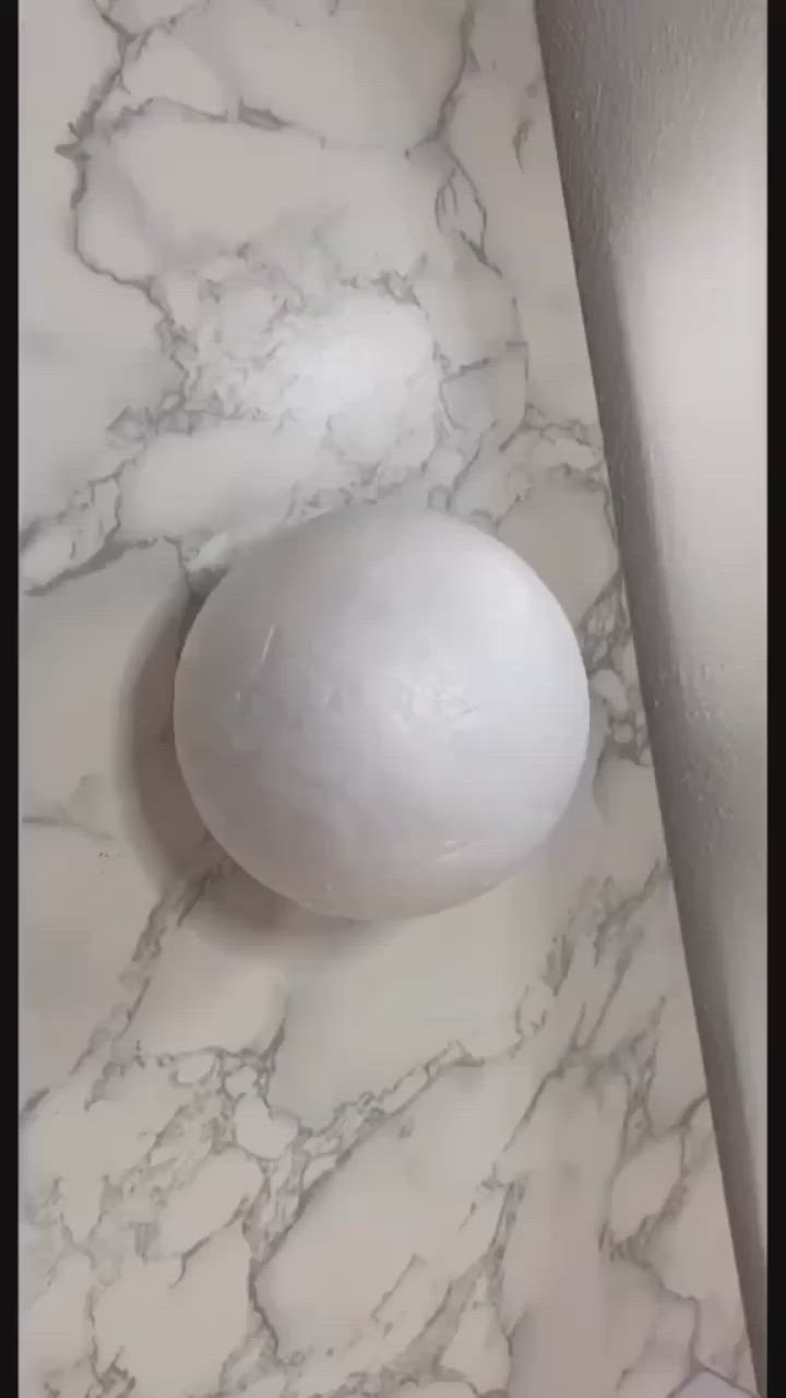 This may contain: a white ball sitting on top of a marble counter