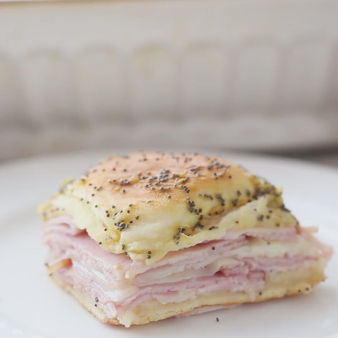 This may contain: two ham sandwiches stacked on top of each other with black sesame sprinkles