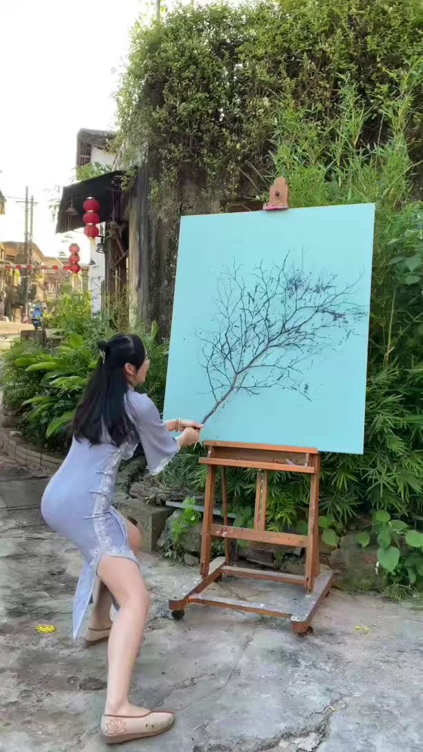 This may contain: a woman is painting on an easel outside