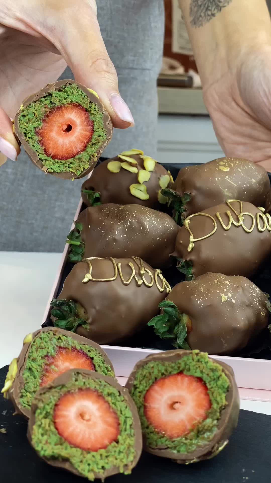 This may contain: chocolate covered strawberries are in a box and someone is picking them up with their fingers