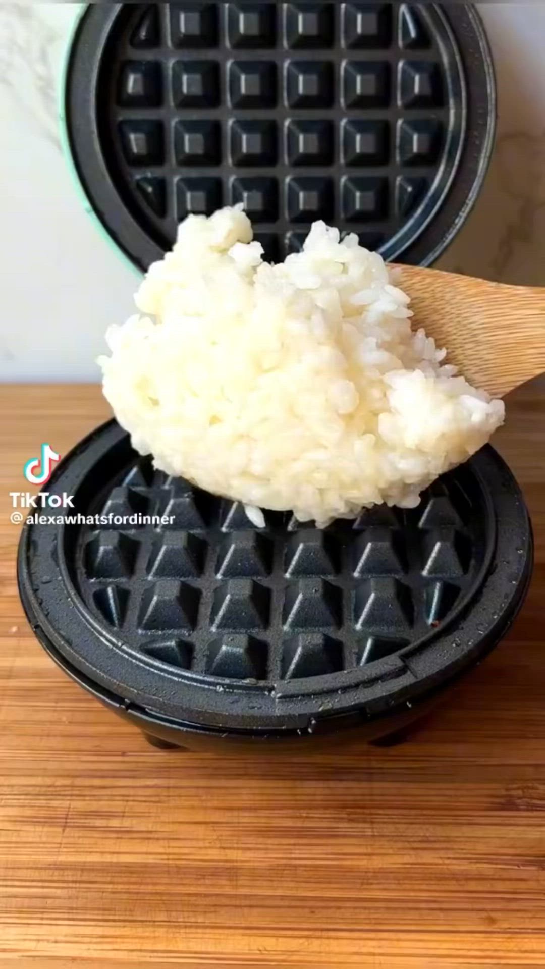 This may contain: a waffle with some white rice on it and a wooden spoon in the middle