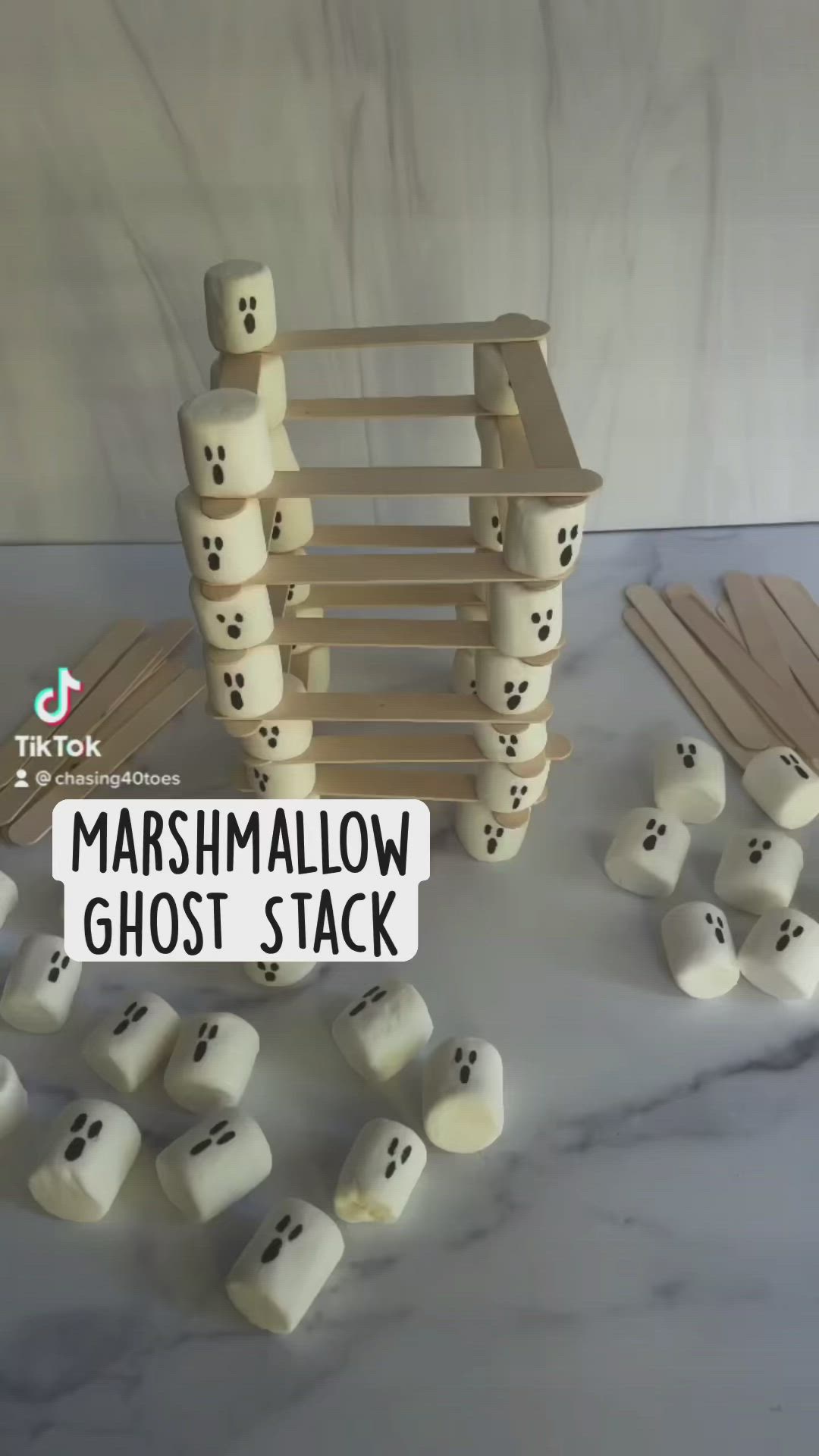 This may contain: the marshmallow ghost stack is made from wood and has black dots on it