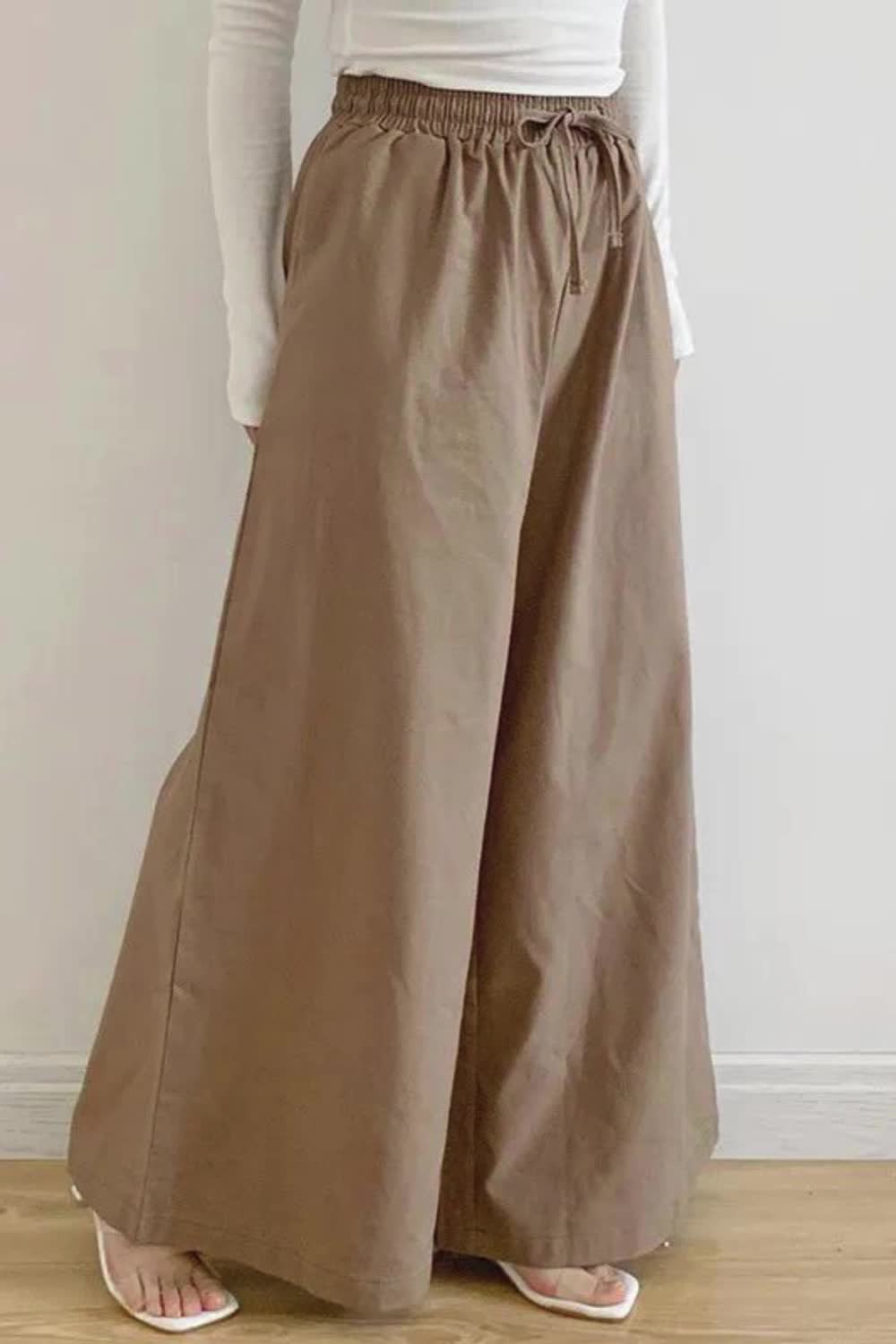 These High-Waisted Loose Pants feature a drawstring for adjustable comfort and a relaxed fit. With built-in pockets and a solid color, they combine practicality with a modern, easygoing style. Ideal for a chic, comfortable look in any casual setting