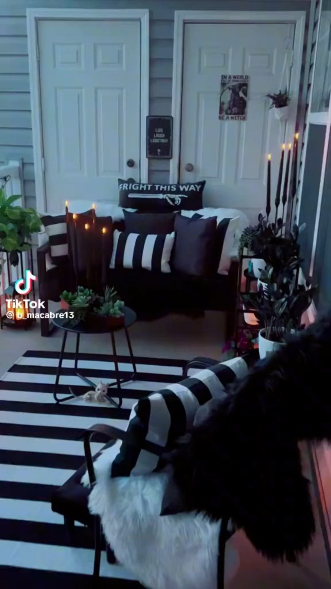 This may contain: a living room with black and white striped rugs on the floor next to a couch