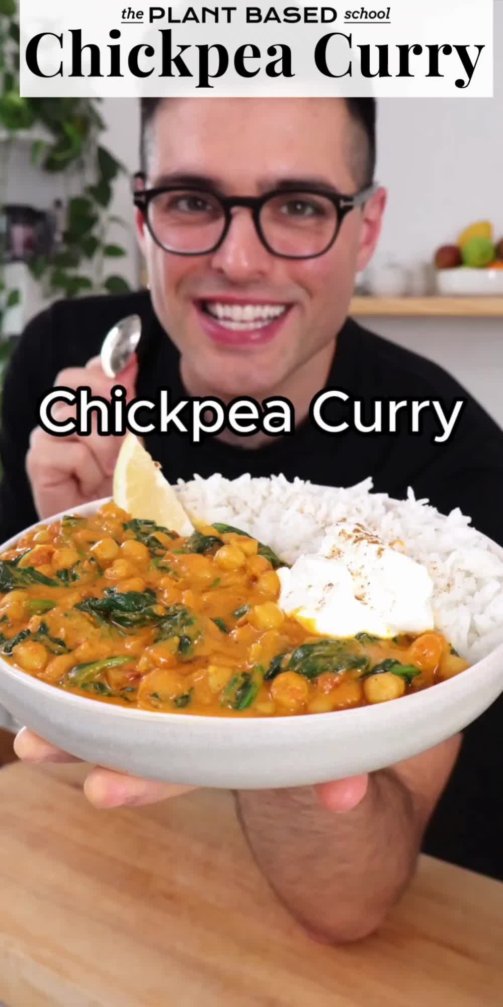 This may contain: a man is holding a bowl of chicken curry