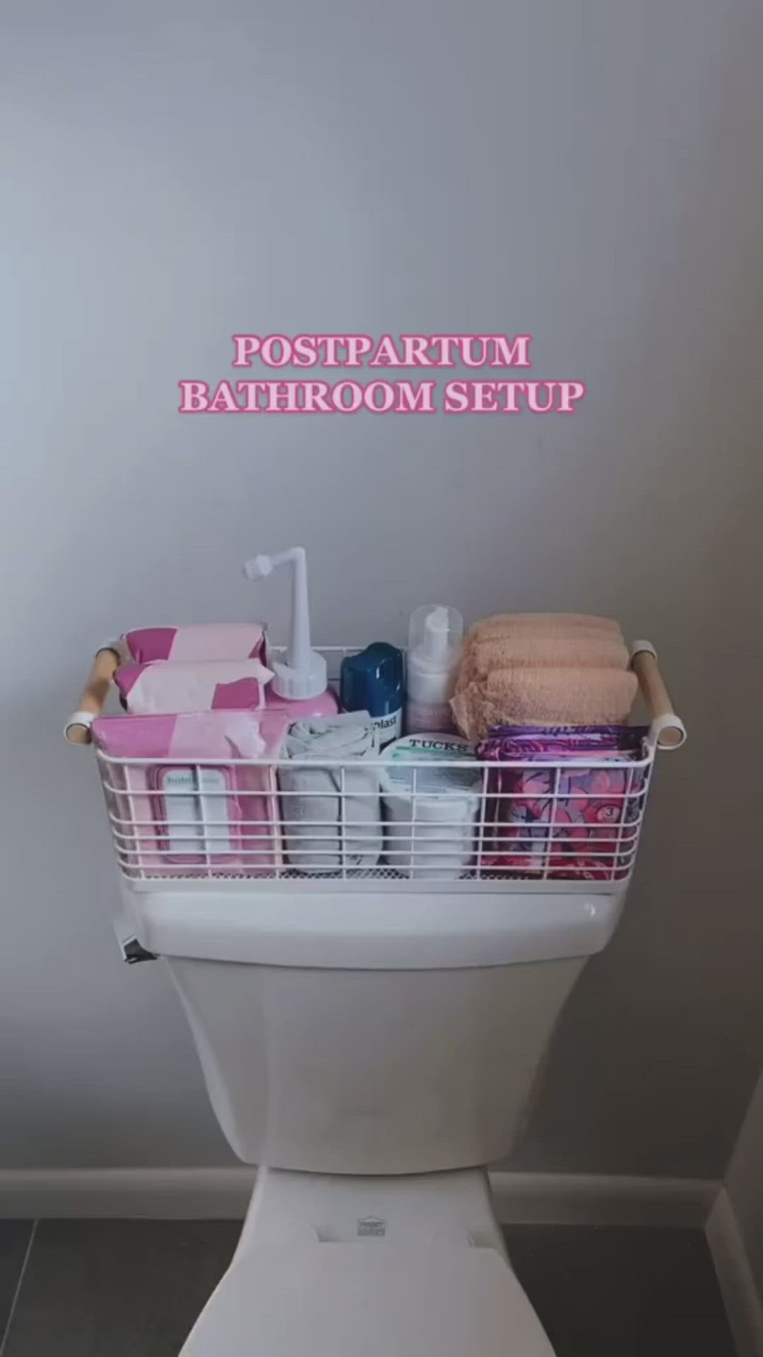 This may contain: a white toilet sitting in a bathroom next to a pink and white sign that says postpartum bathroom setup