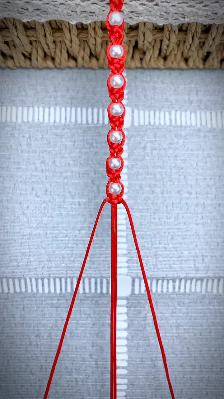 This may contain: a close up of a red object hanging from a ceiling fixture with strings attached to it