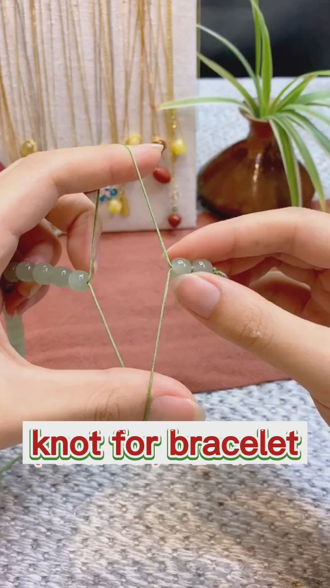 This may contain: two hands holding small pieces of string with the words knot for bracelet