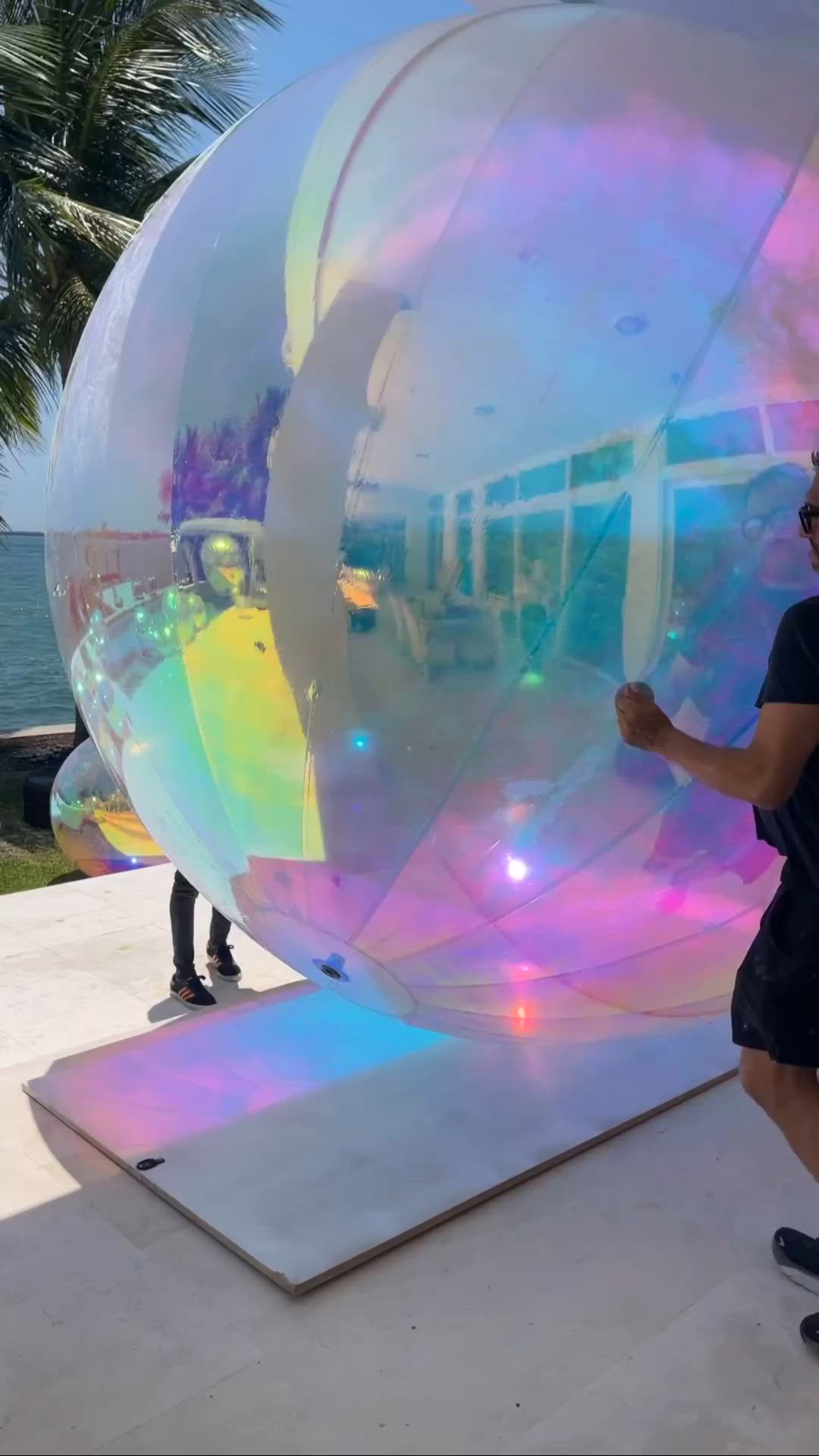 This may contain: a man standing in front of a giant bubble ball