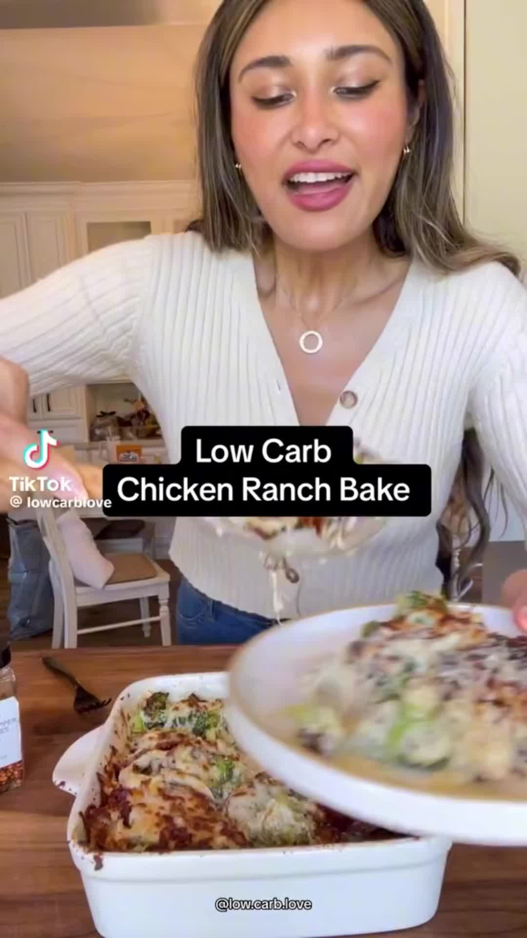 This may contain: a woman holding a bowl of chicken ranch bake in front of her face with the words low carb chicken ranch bake