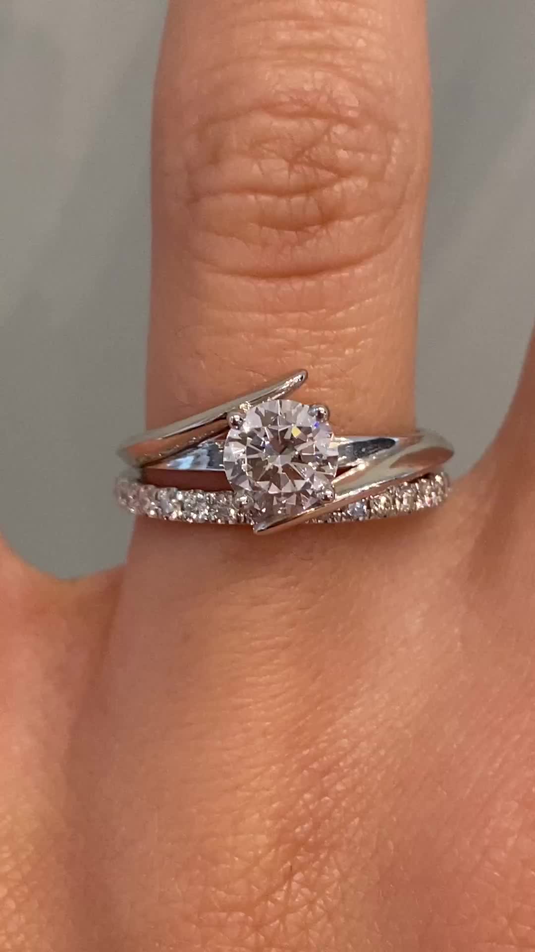 Our client wanted something unique and modern - yet something with a bit of twist - her wish was our command. In the center of this beautiful platinum setting you will find a vibrant round diamond secured within a bypass band design. Approx Band Width (mm): 2.15mm Approx Production Time: 5-6 weeks Drop-down diamond options represent our recommended grade, which maximizes size for value, while maintaining eye-perfect clarity and giving you a colorless look. For other diamond options, see our Shop