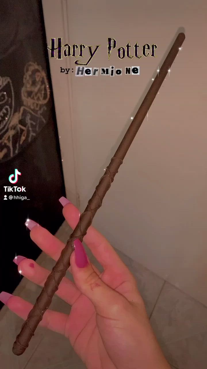 This may contain: a person holding a harry potter wand in their hand