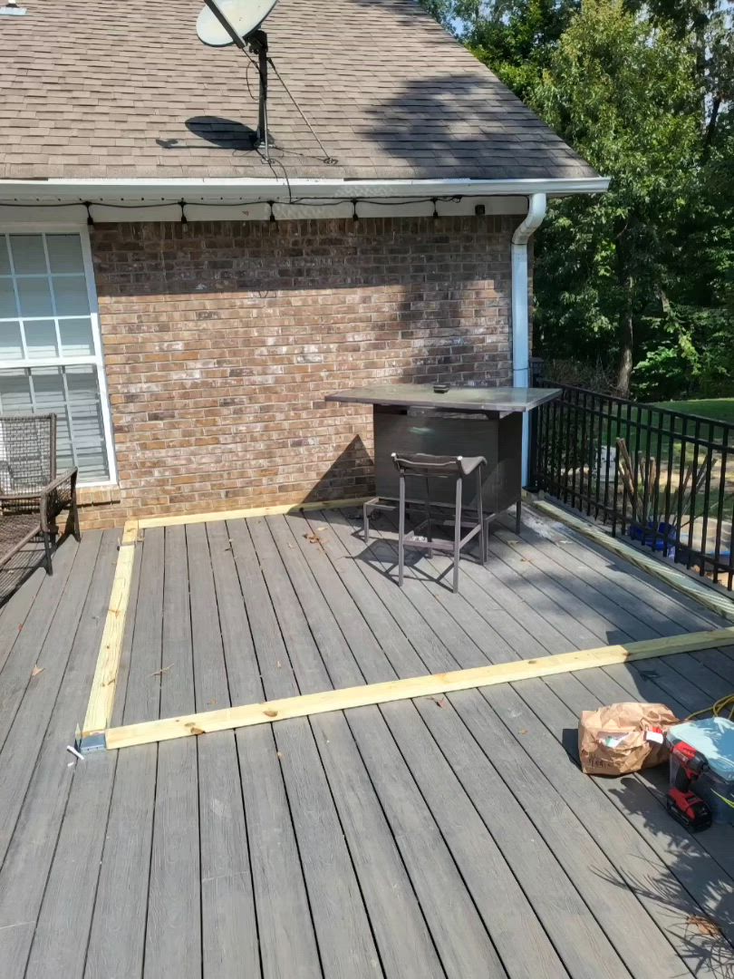 This may contain: an outdoor grill on a deck in front of a house