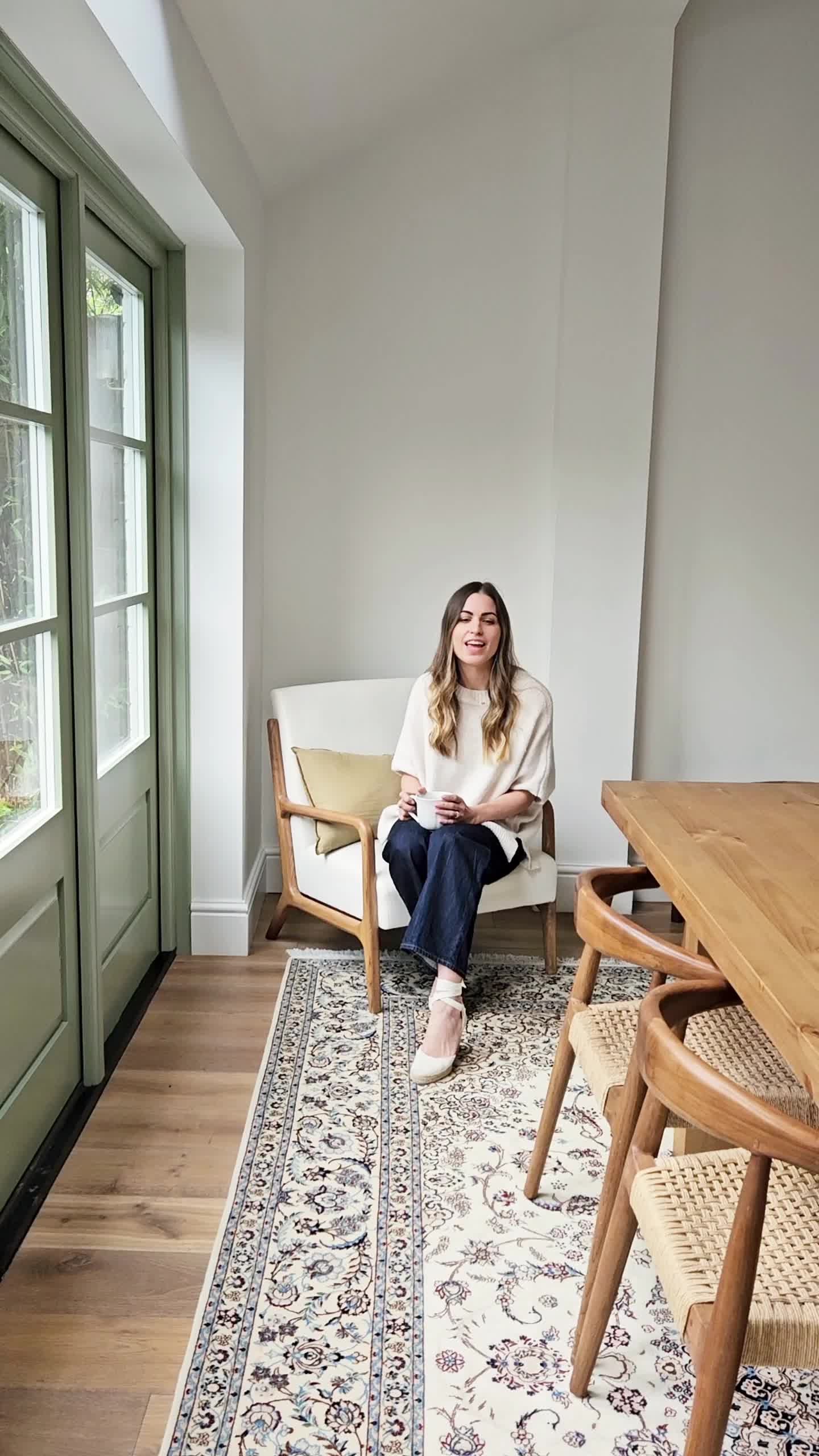 This may contain: a woman sitting in a chair next to a table with chairs on top of it