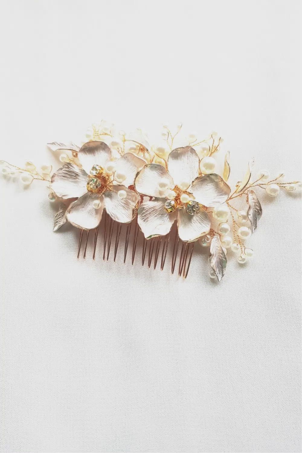 Floral hair comb for weddings. This bridal hair comb contains two gorgeous light gold flowers as a centerpiece and is handmade with pearls, light gold leaves, and rhinestones. This ethereal and romantic comb is perfect for the bride looking for floral hair accessories with an elegant touch. This bridal flower hair comb is great for the vintage bride, the bohemian bride, and the romantic bride.