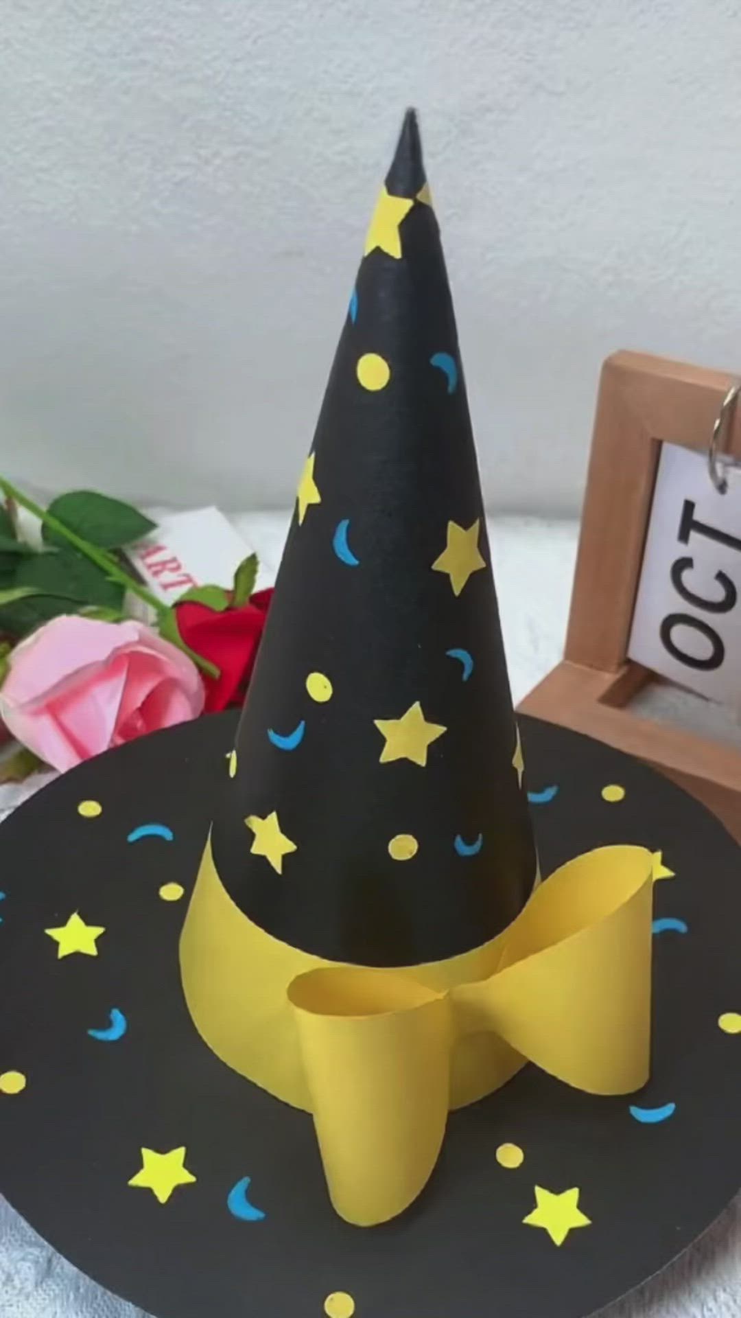 This may contain: a black hat with yellow stars on it and a wooden plaque next to it that says congratulations