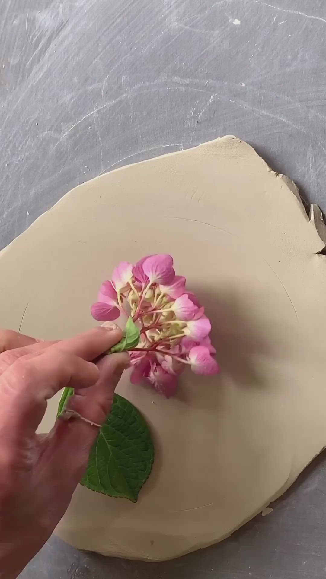 This may contain: someone is making a flower out of clay