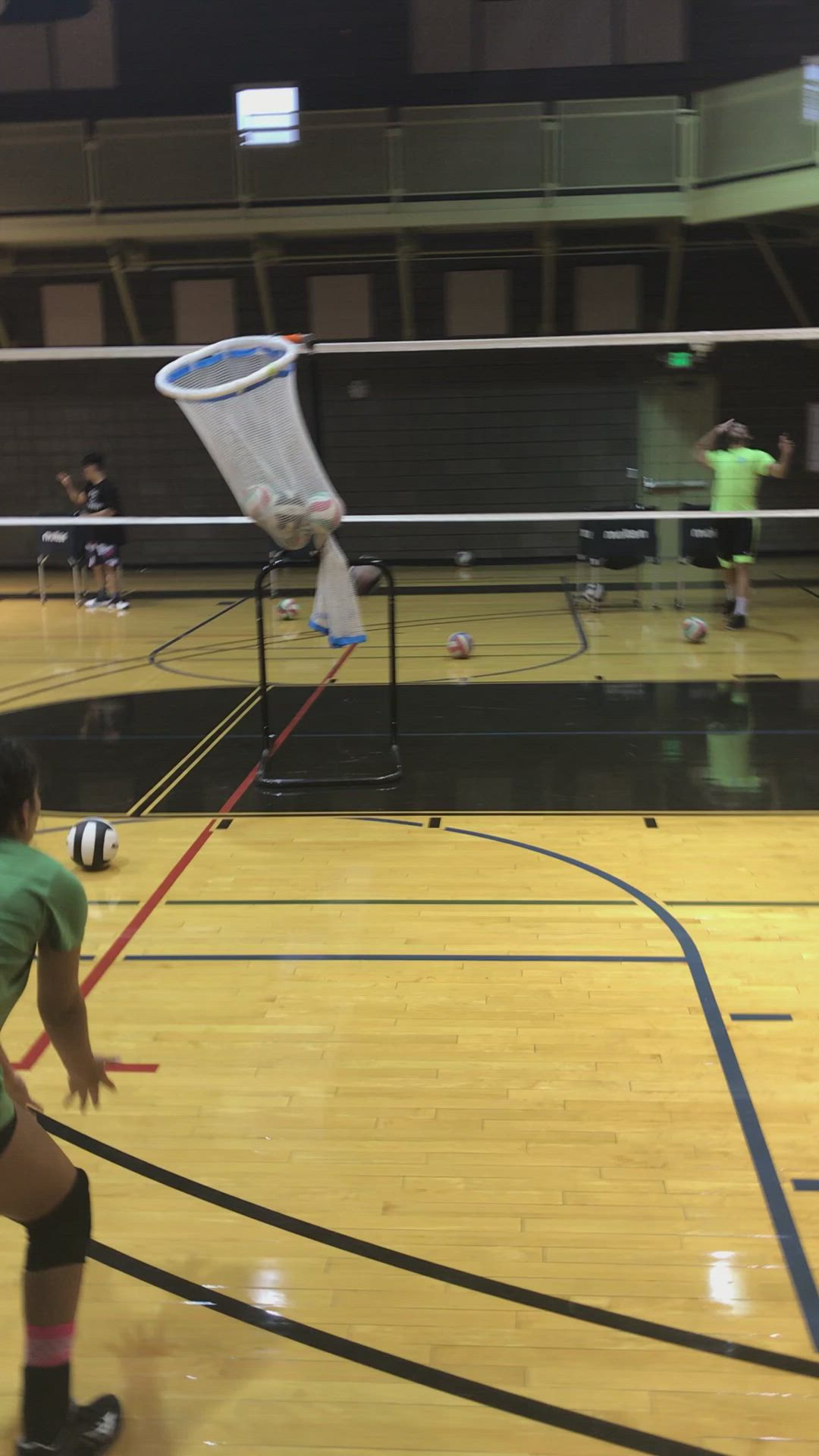 This may contain: two girls playing volleyball in an indoor gym