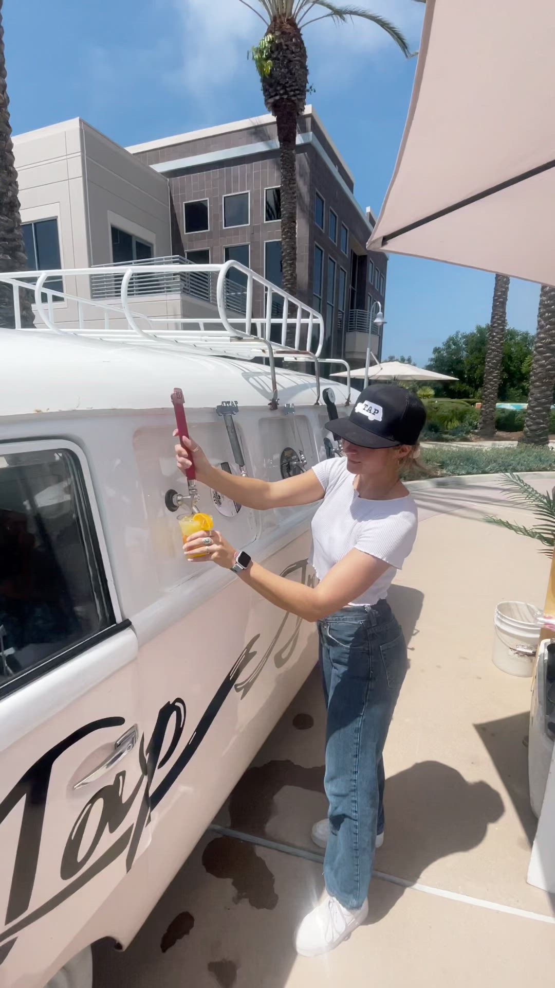 This may contain: a woman is painting the side of a white car with yellow spray paint on it