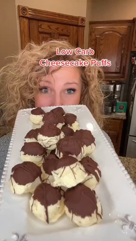 This may contain: a woman is holding up a plate with chocolate covered cookies in front of her face