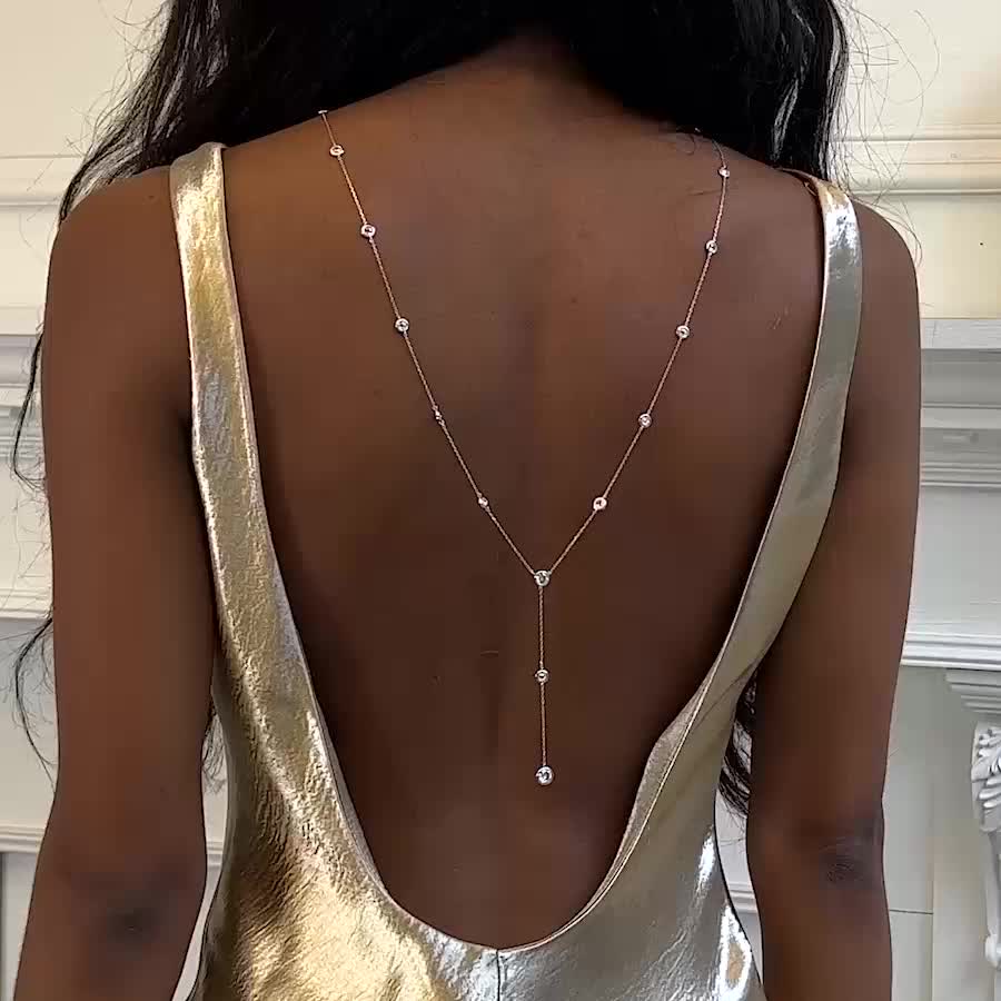 The ultimate backdrop necklace for a V-shape low back dress! This Y Lariat Cubic Zirconia chain backdrop necklace is the perfect accessory. Easy to wear, hangs over your shoulders. Choose your front style (two or one row) and while the back features a Y design. Put on easily over your head. Light weight and durable; made to fit you perfectly in NYC! Featured on Buzzfeed .925 Sterling Silver Cubic Zirconia Crystals, 5mm Hypoallergenic, lead and nickel free Back Length Options: 10in (25.4cm), 12 i