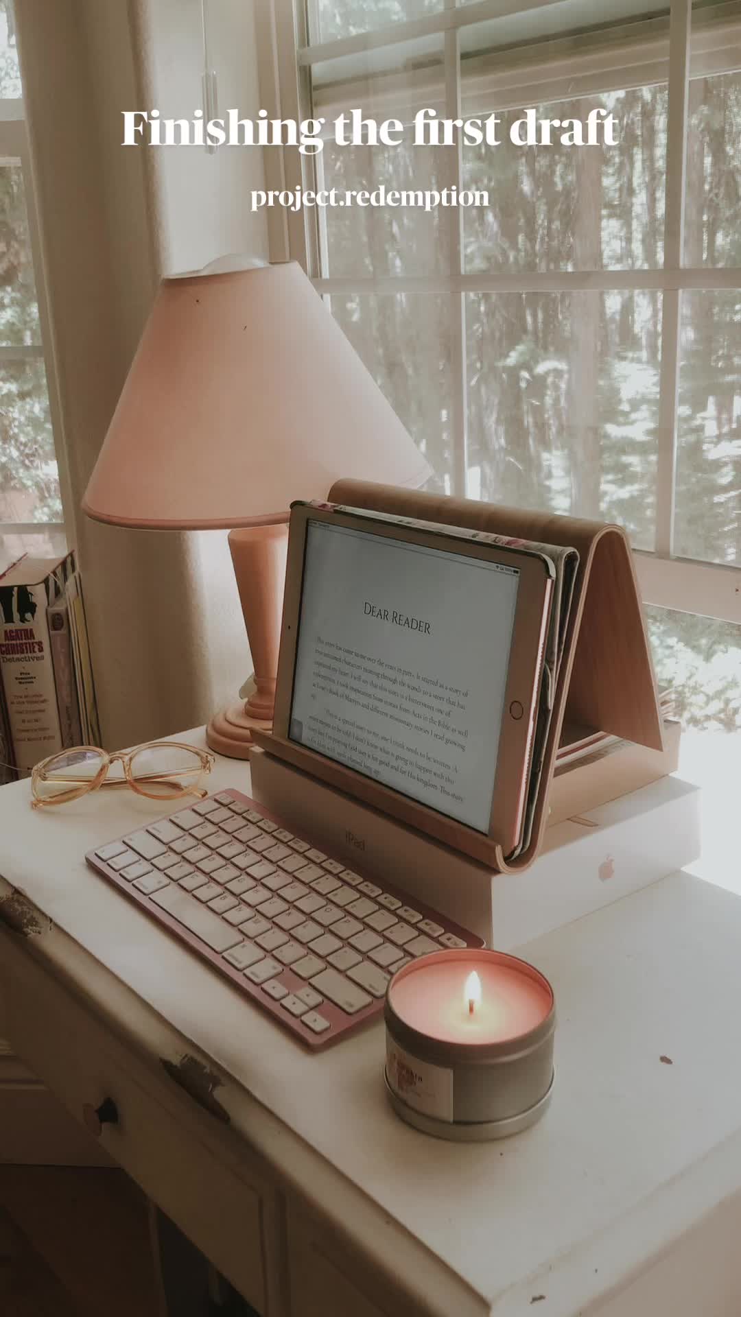 This may contain: a laptop computer sitting on top of a desk next to a lamp and a window