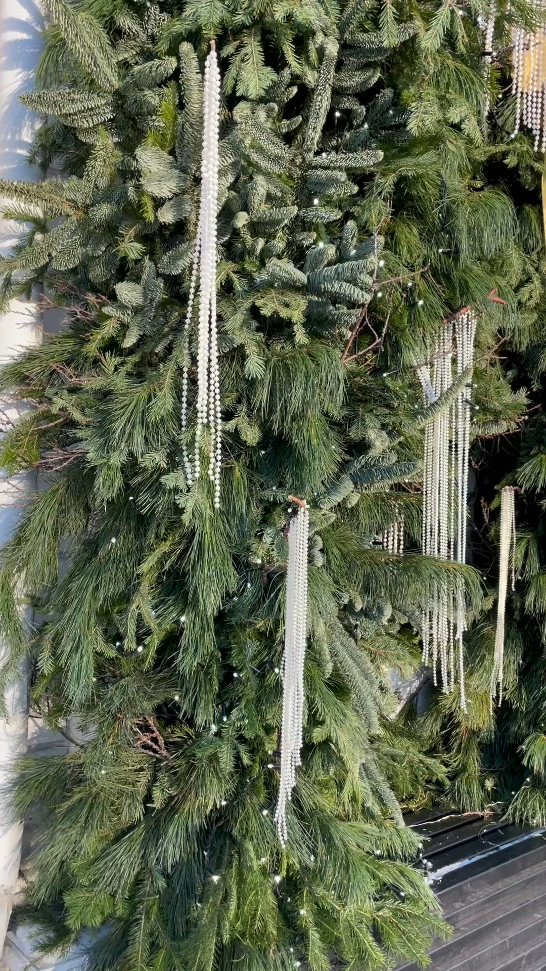 This may contain: a christmas tree is hanging from the side of a building