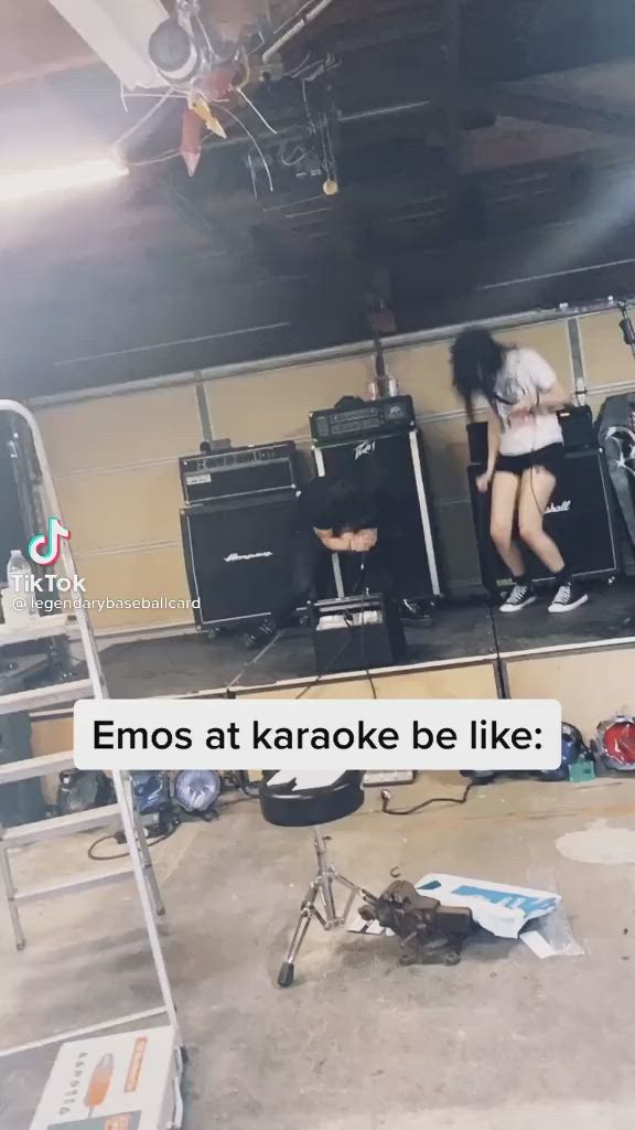 This may contain: two people on stage with guitars in front of them and the words emos at karaoke be like