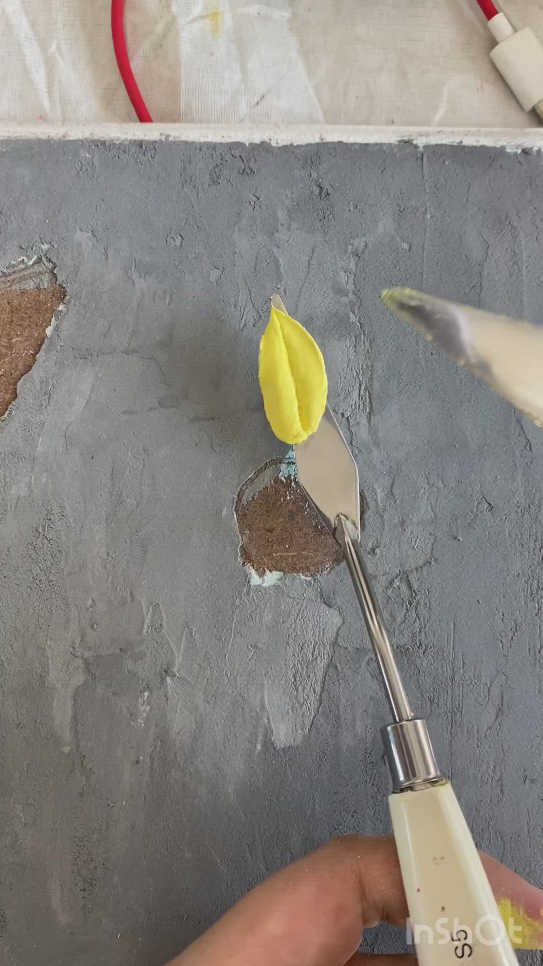 This may contain: a person is using a pair of scissors to paint the wall