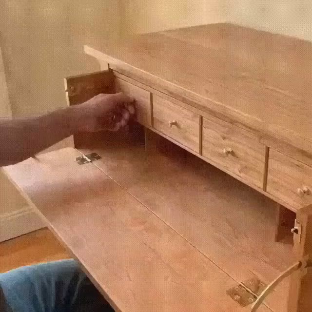 This may contain: a person is opening the drawer on a desk